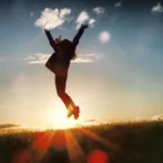 Silhouette of a person jumping over a horizon, signifying their joy at achieving more business success by developing more future-ready skills