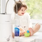 A joyful toddler on a table with toy, alongside HomePure Viva, encouraging a cheerful and healthful lifestyle.