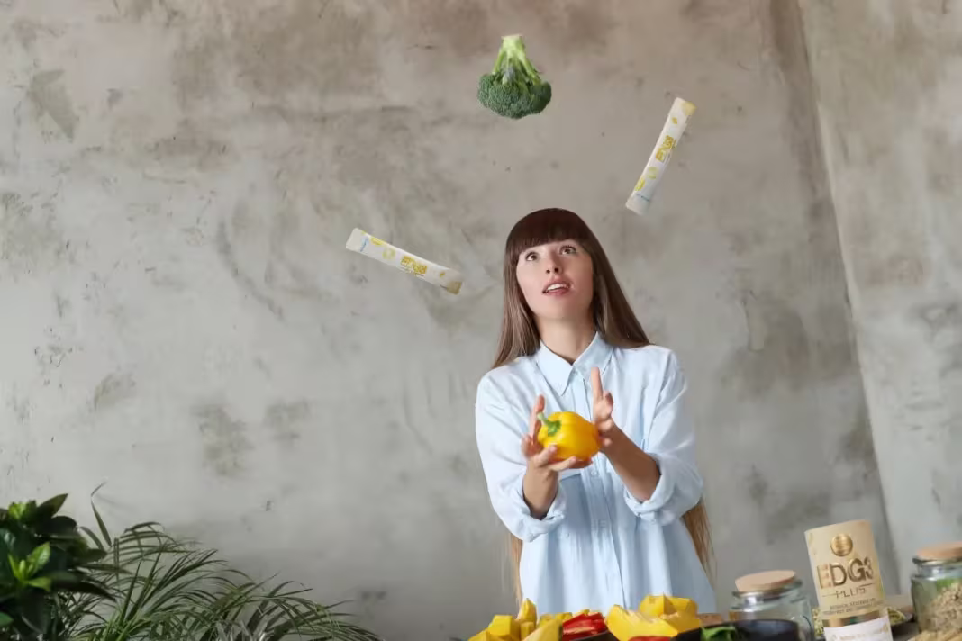 Why More People Are Switching To Vegan And Vegetarian Diets 4 Woman who enjoys a plant-based diet juggling EDG3 Plus packets with broccoli and bell pepper