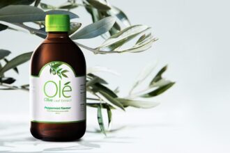 Bottle of Ole Olive Leaf Extract in front of olive leaves