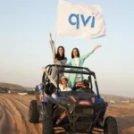 V-Convention Girls on a jeep with a QVI flag, riding in the desert where they enjoyed stress-free travel to for their holiday