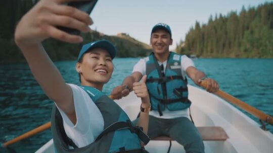 Couple wearing QVI hats on a boat in the lake smiling