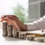 image of hand counting stacks of coins