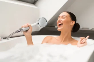 Lady in bathtub using HomePure Rayn shower head as a microphone