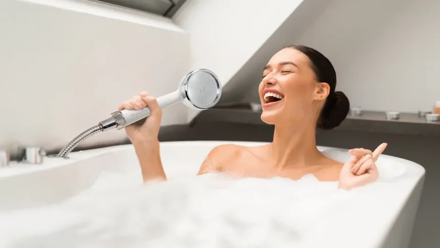 Lady in bathtub using HomePure Rayn shower head as a microphone