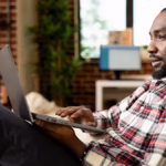 Man looking at laptop | Is QNET a Scam?